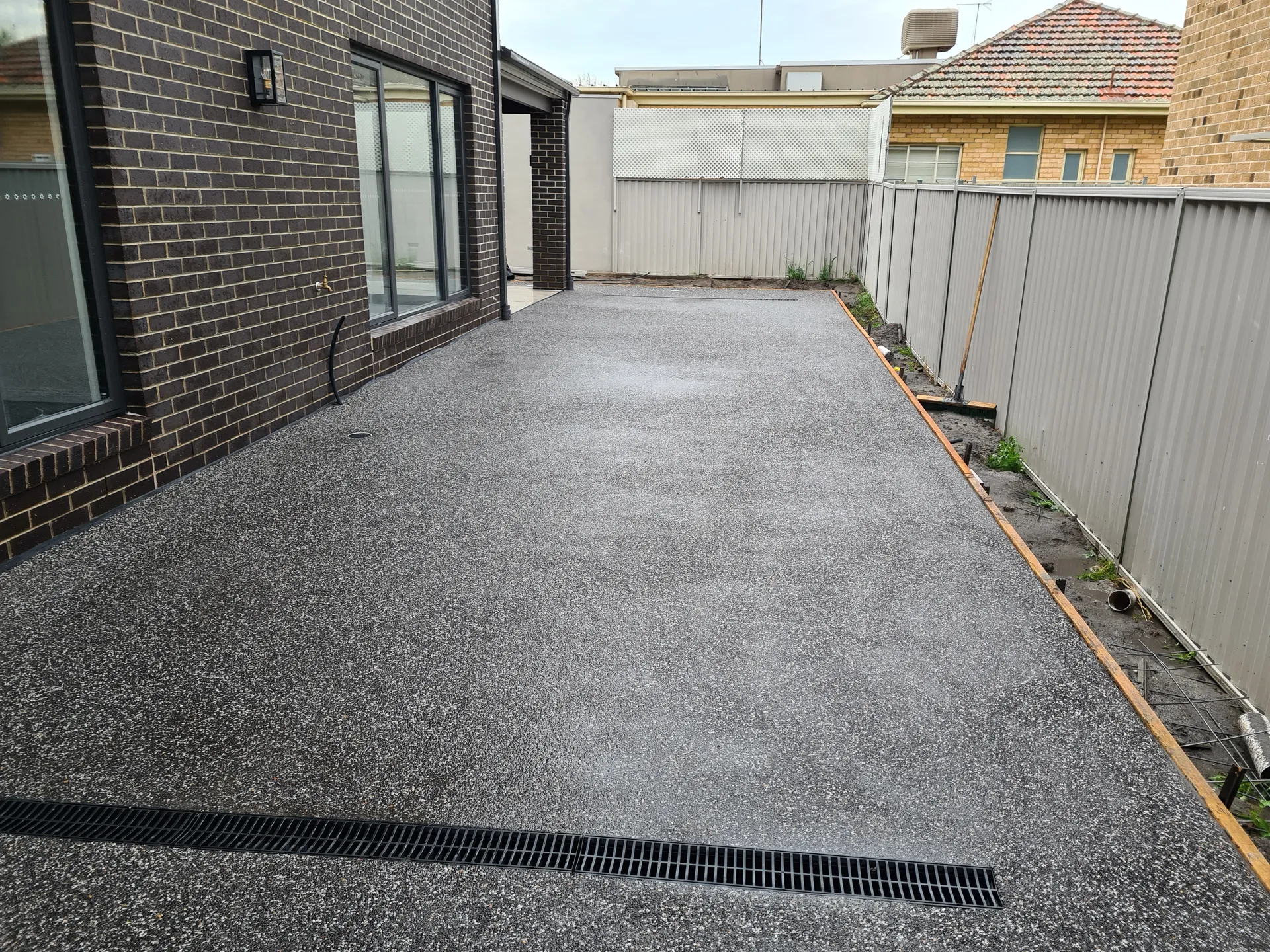 Exposed aggregate driveway showing drainage channels in foreground